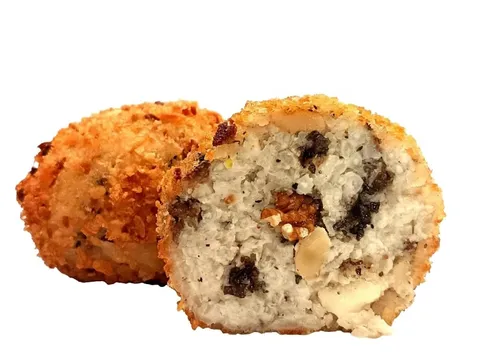 Arancino Tartufo, Pecorino e Noci tagliato a metà, riso chiaro con tartufo e noci, accanto a un arancino intero