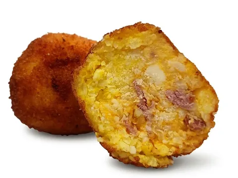 Arancino Zucca e Speck tagliato a metà, riso giallo-arancio con pezzetti di speck